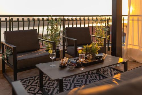 a patio with two chairs and a table with wine glasses at Apartment Mozart in Šibenik