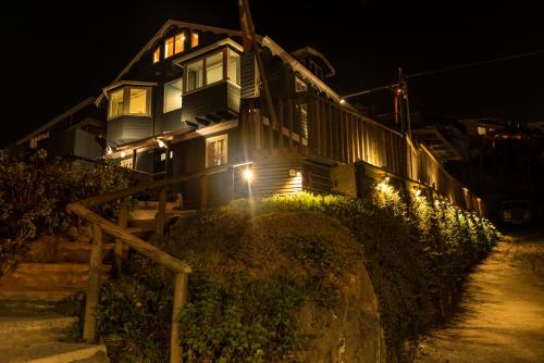a house with lights on the side of it at night at Hotel Faro Azul Valparaíso Cerro Alegre in Valparaíso