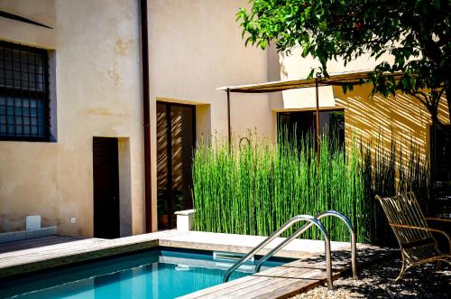 a swimming pool with a chair and some tall grass at Palazzo Maresgallo Suites & SPA in Lecce