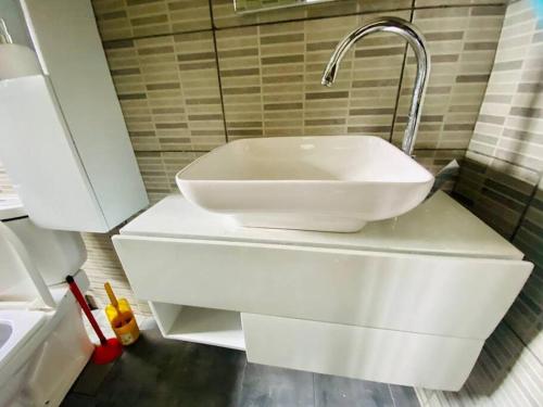 ein weißes Waschbecken mit einem Wasserhahn im Bad in der Unterkunft Villa meublée au vert 