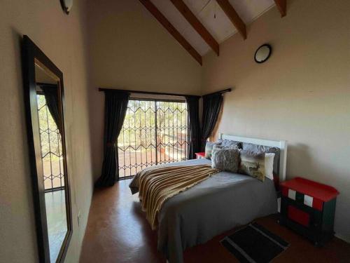 a bedroom with a bed and a large window at Hakuna Matata-Bela Bela in Moheme