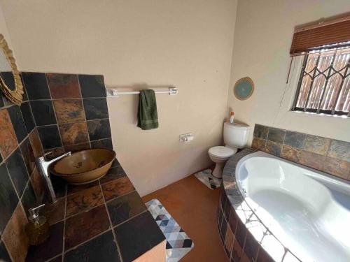 a bathroom with a large tub and a toilet at Hakuna Matata-Bela Bela in Moheme