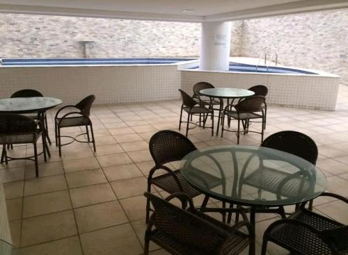 a patio with tables and chairs and a pool at Studio completo na praia de Manaíra, apt 213 in João Pessoa