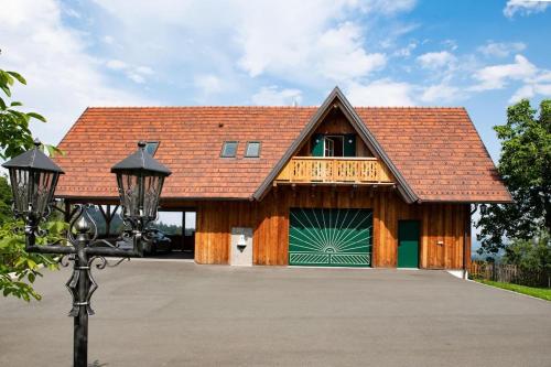 une maison avec un garage avec une porte de garage verte dans l'établissement Chalet-Südsteiermark - traumhafte Aussicht, Infinity Pool, Privatsphäre, Klima und de-luxe Ausstattung, à Schwanberg