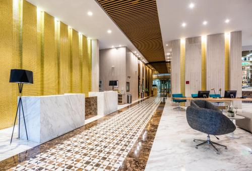 an office with a lobby with yellow walls and chairs at Crowne Plaza Barranquilla by IHG in Barranquilla