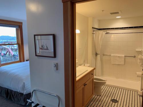 a bedroom with a bed and a bathroom with a shower at Inn At Creek Street in Ketchikan