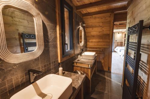 uma casa de banho num chalé de madeira com um lavatório e um espelho em Chalet de prestige Pyrénéen, 3 min des télécabines em Vignec