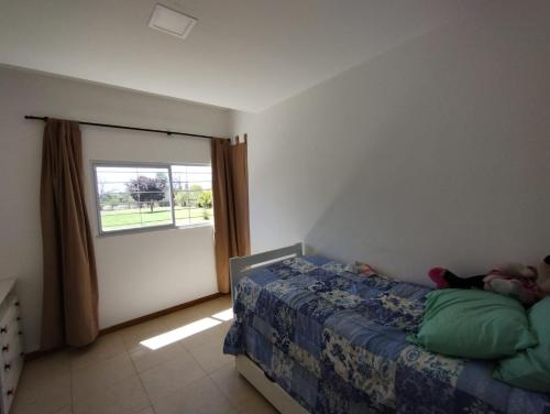 Schlafzimmer mit einem Bett und einem Fenster in der Unterkunft Finca Los Sauces in Chilecito