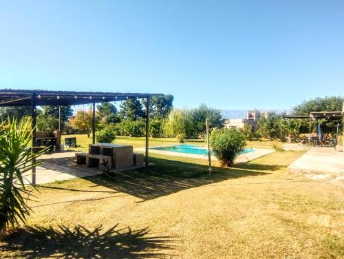 a backyard with a swimming pool and a pavilion at Finca Los Sauces in Chilecito