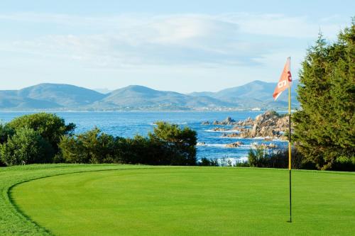 a golf course with a view of the ocean at Due Lune Puntaldia Resort & Golf in San Teodoro