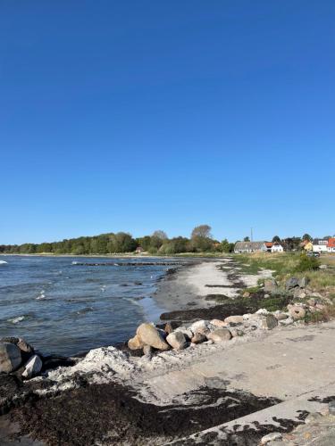 a body of water with rocks on the shore at beach room in Snogebæk