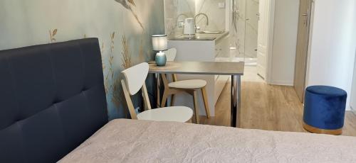 sypialnia ze stołem i krzesłami obok łóżka w obiekcie WOW FLOU Przystań Letnica Apartamenty 700m plaża w Gdańsku