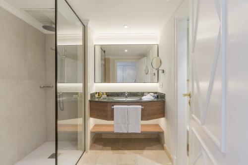 a bathroom with a sink and a shower with a mirror at Denia Marriott La Sella Golf Resort & Spa in Denia