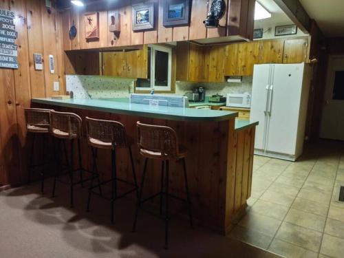 cocina con barra con taburetes y nevera en Lake Almanor Country Club Rustic Retro Cottage en Prattville