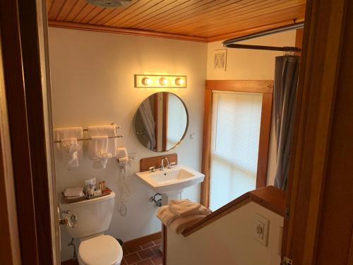 a bathroom with a sink and a toilet and a mirror at Inn At Creek Street in Ketchikan