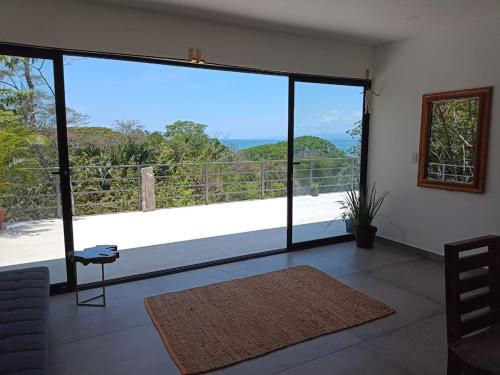 a living room with a large window with a view at Laurel Jungle & Ocean in Santa Teresa Beach