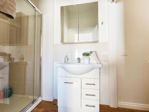 a bathroom with a sink and a shower at On The Beach, Kids & Pets Friendly in Frankston