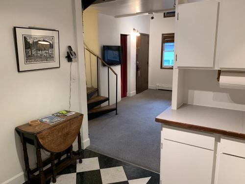 a room with a kitchen with a table and a hallway at Inn At Creek Street in Ketchikan
