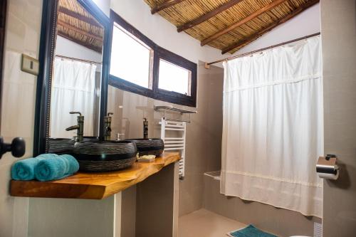 W łazience znajduje się blat z umywalką i lustrem. w obiekcie Lodge Atacama Horse w mieście San Pedro de Atacama