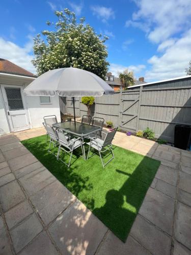 un patio con mesa, sillas y sombrilla en Spacious 4 bedroom House with a Private Garden en Londres
