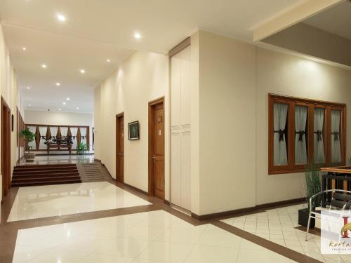 a hallway with white walls and a staircase in a house at Kertanegara Premium Guest House in Malang