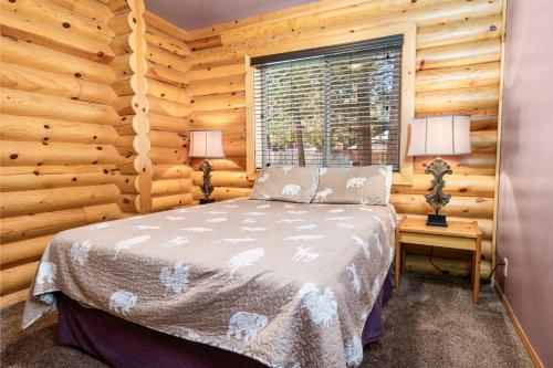 een slaapkamer met een bed in een blokhut bij 3 Cubs Lakefront - Stunning lakeside home with Hot Tub, Foosball, and Lake View in Big Bear Lake