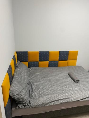 a bed with a yellow and blue head board at Rajska 14B in Gdańsk
