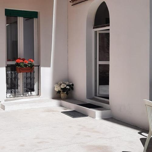 a porch with two windows and a window seat with flowers at La Llua Alghero in Alghero