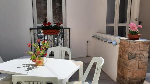 a white table and chairs with flowers on a balcony at La Llua Alghero in Alghero