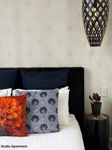 a bed with a blue headboard with a pillow and a table at Private apartments in a Landmark Heritage Building in Auckland