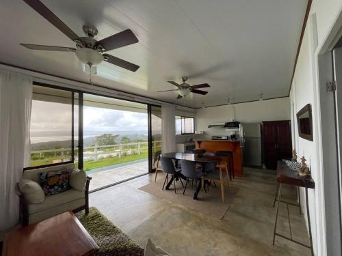 uma sala de estar com uma ventoinha de tecto e uma mesa em Casa Felipe, lake view-cottage em Nuevo Arenal