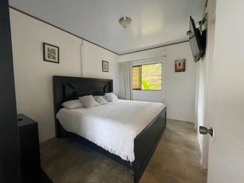 um quarto com uma cama grande e uma janela em Casa Felipe, lake view-cottage em Nuevo Arenal