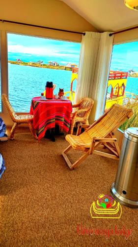 a room with a table and chairs and the water at Uros Maya Lodge in Puno