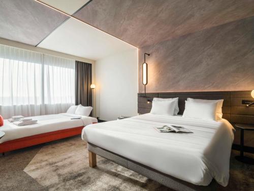 een hotelkamer met 2 bedden en een raam bij Novotel Rotterdam Brainpark in Rotterdam
