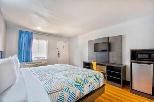 a hotel room with a bed and a television at Motel 6-Sulphur, LA in Sulphur