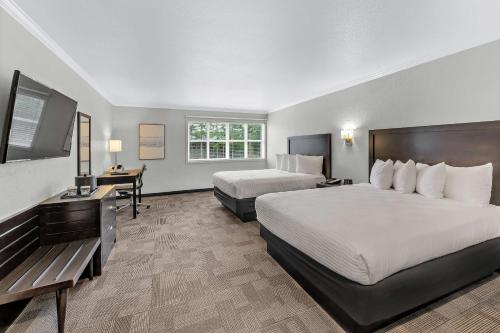 a hotel room with two beds and a desk at Best Western Wesley Inn & Suites in Gig Harbor
