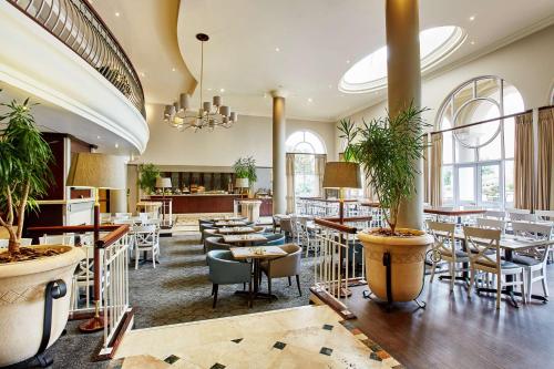 a restaurant with tables and chairs in a room at StayEasy Century City in Cape Town