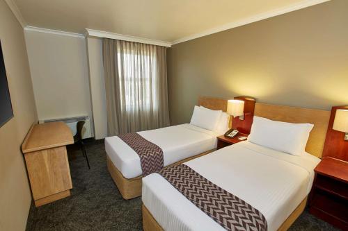 Postel nebo postele na pokoji v ubytování StayEasy Century City
