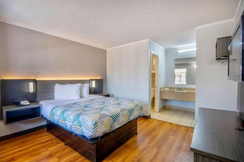 a hotel room with a bed and a bathroom at Motel 6 Bossier City, La in Bossier City