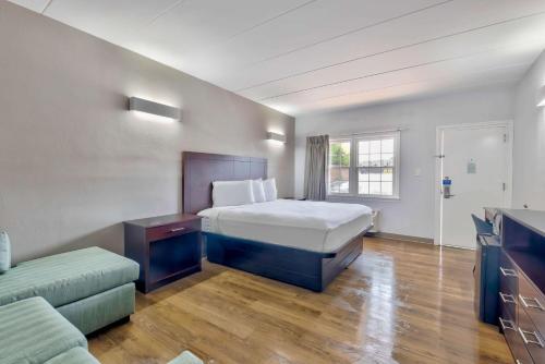 a hotel room with a bed and a couch at Motel 6-Falls Church, VA - Arlington Boulevard in Falls Church