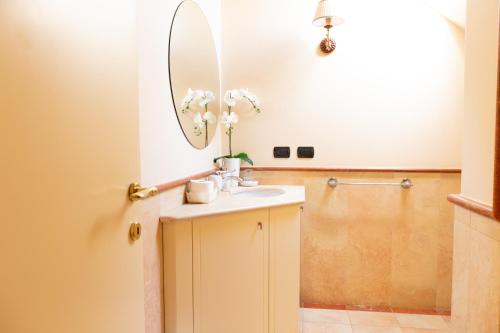 W łazience znajduje się umywalka i lustro. w obiekcie Villa Rolls - Porzione di Villa con piscina,giardino e parcheggi w mieście Riccione