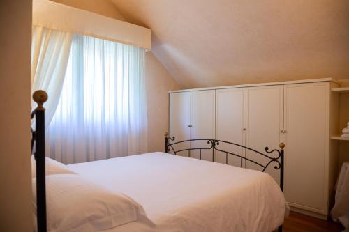 sypialnia z białym łóżkiem i oknem w obiekcie Villa Rolls - Porzione di Villa con piscina,giardino e parcheggi w mieście Riccione