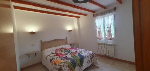 um pequeno quarto com uma cama e uma janela em ALOJAMIENTOS EL CASTRO em Taramundi