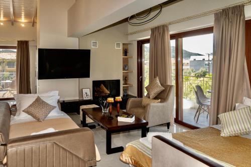 a living room with a couch and a tv at Emily Apartments in Nydri