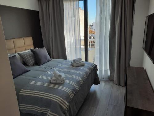 a hotel room with a bed with towels on it at In House BA - Le coq in Buenos Aires