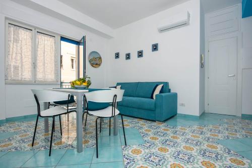 een woonkamer met een tafel en stoelen en een bank bij Casa Sammarco in Minori