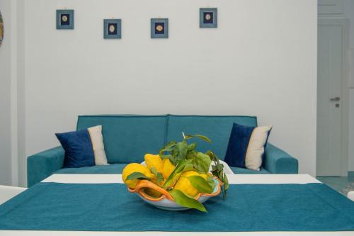 a bed with a blue couch and a bowl of fruit at Casa Sammarco in Minori