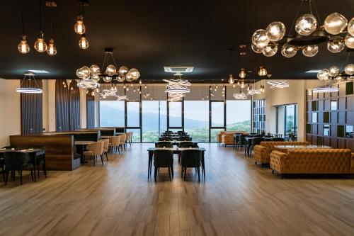 a restaurant with tables and chairs and large windows at Gaya Residences in Shahdag
