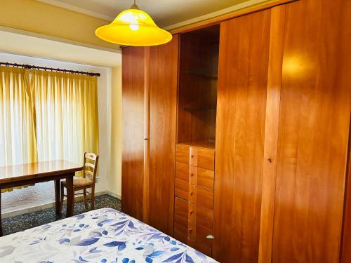 1 dormitorio con cama, escritorio y armario de madera en Como en Casa, en Valencia
