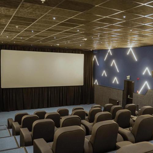 a cinema room with a blank screen and chairs at Gaya Residences in Shahdag